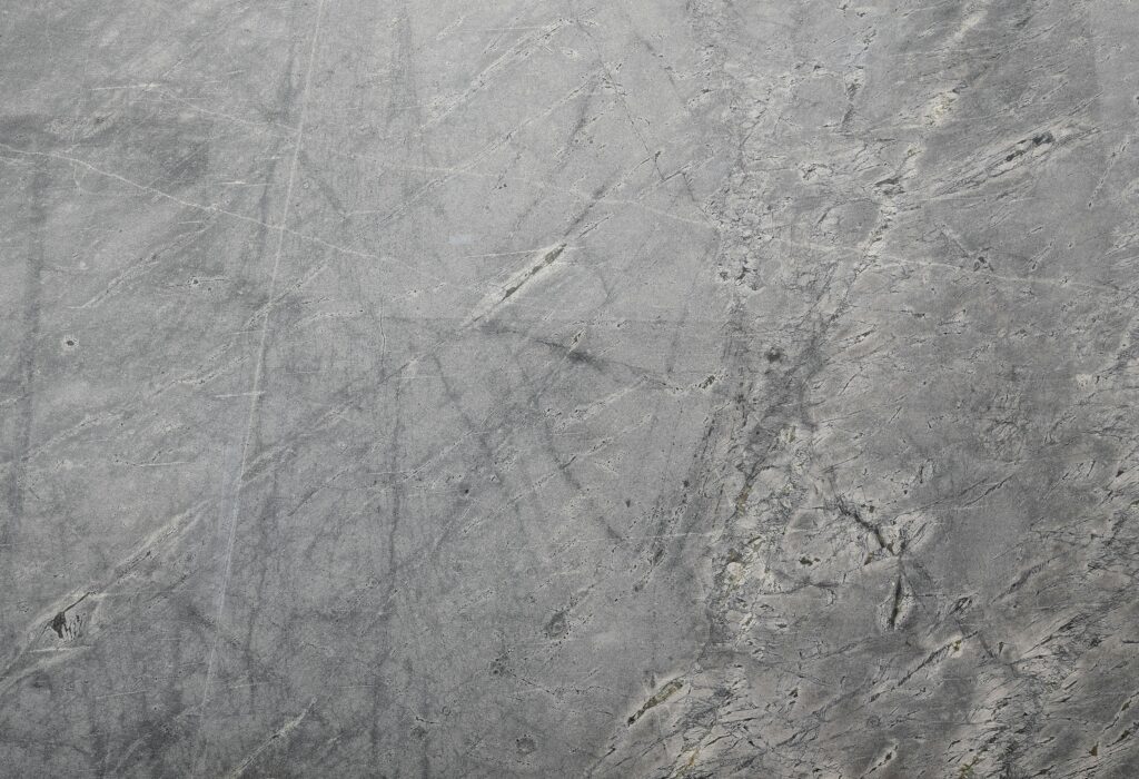 Close-up of a textured grey stone surface suitable for backgrounds or wallpapers.